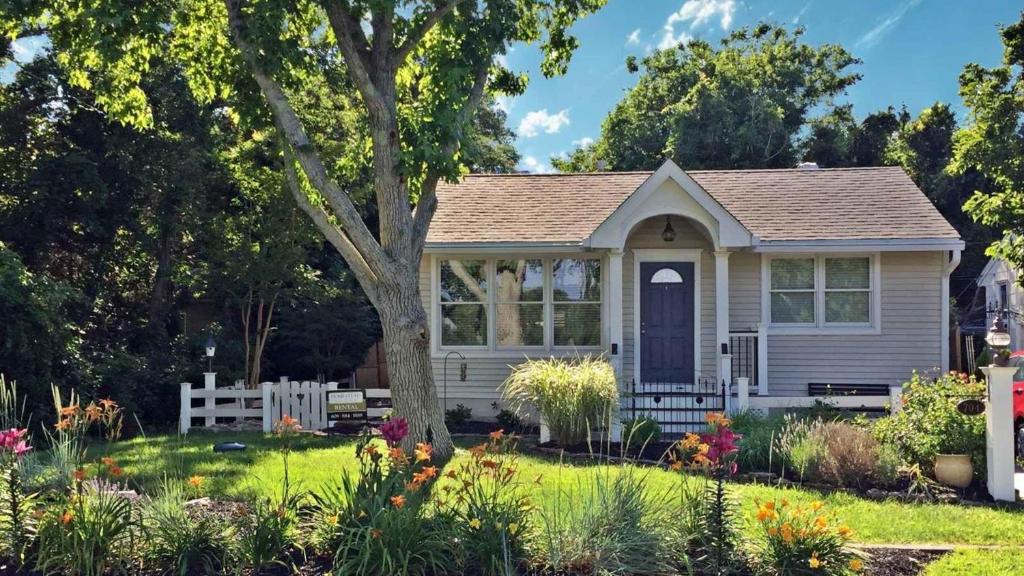 a small white house with a tree in a yard at Lakeview Retreat in Cape May Point