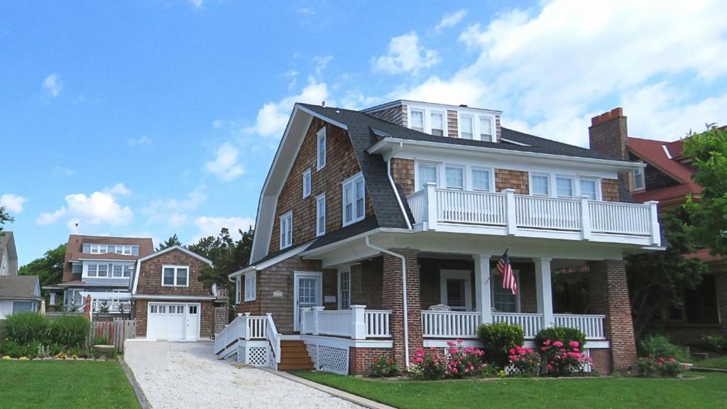a brick house with a porch and a balcony at The Cape May Diamond in Cape May