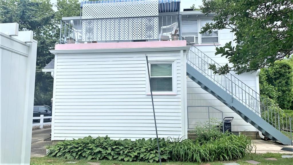 a white house with a staircase on the side of it at Rulons Cape May Diamond, 2Nd in Cape May