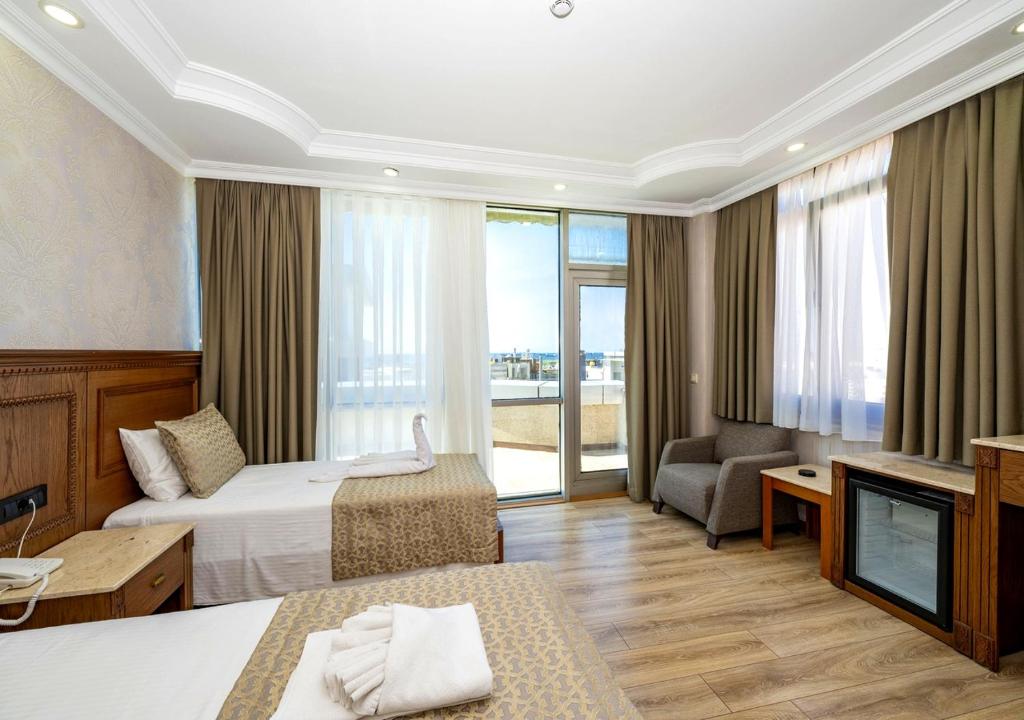 ein Hotelzimmer mit zwei Betten und einem Fernseher in der Unterkunft Dalan Otel Istanbul Old City in Istanbul