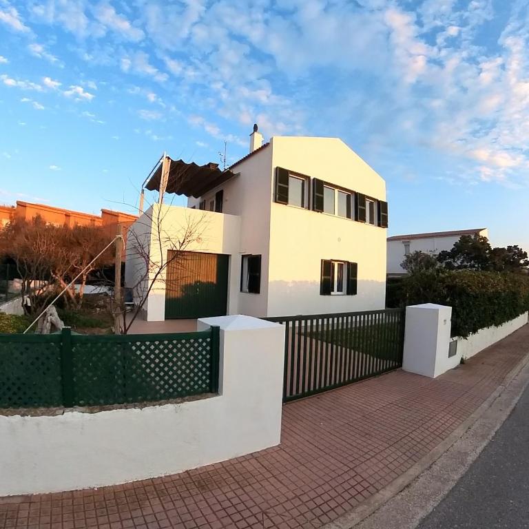 a white house with a fence in front of it at Villa Tord Massot 11 in Ciutadella