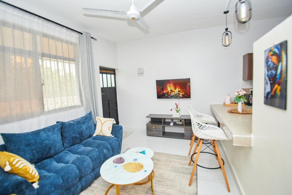 a living room with a blue couch and a table at Diani Dream stays in Diani Beach