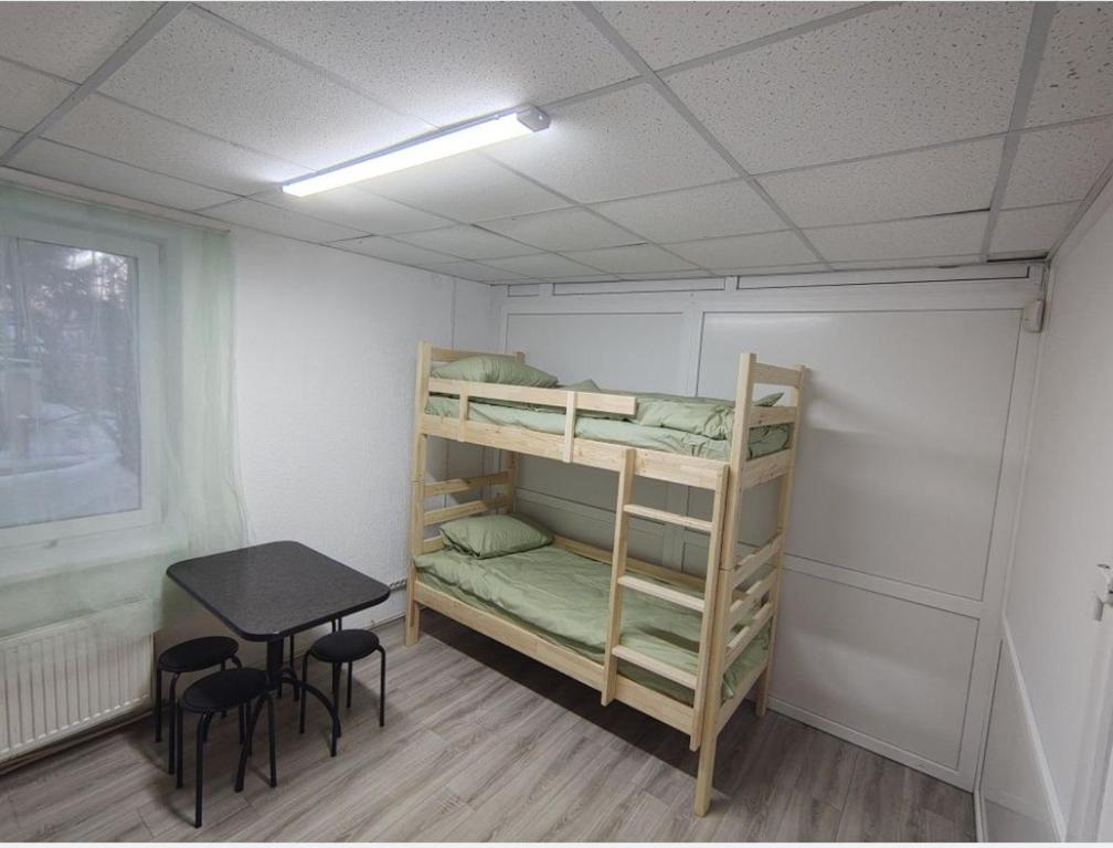 a small room with bunk beds and a table at Ліза in Irpin