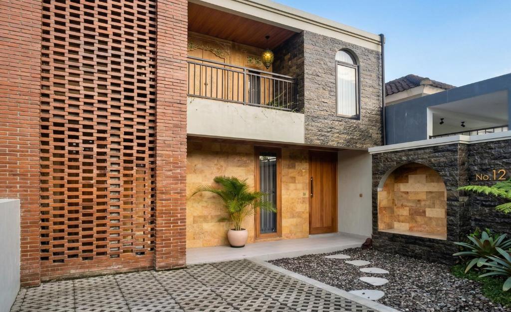 an external view of a brick house with a potted plant at Juminten Villa in Ubud