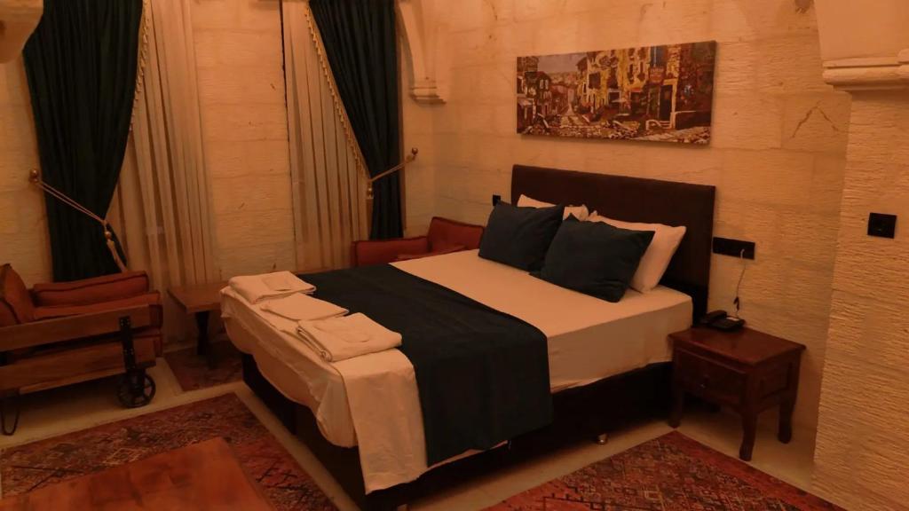 a bedroom with a large bed and a chair at Helen Olimpos Konağı in Mardin