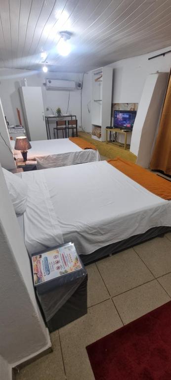 a room with two beds in a room with avertisement at Ypane Residencial in Ypane