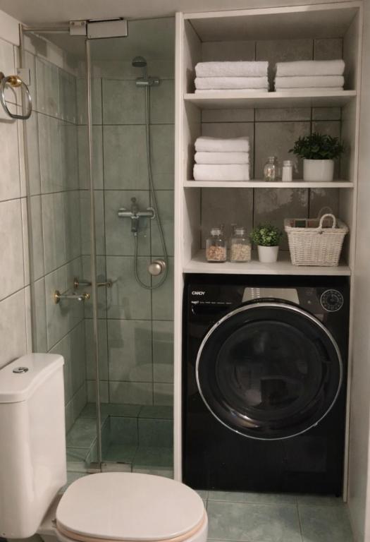 a washing machine in a bathroom with a shower at A&S Luxury Apartment in Kavála