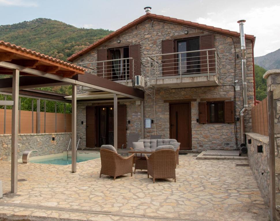 a stone house with a patio and a swimming pool at Villas Kertezi in Kalavrita