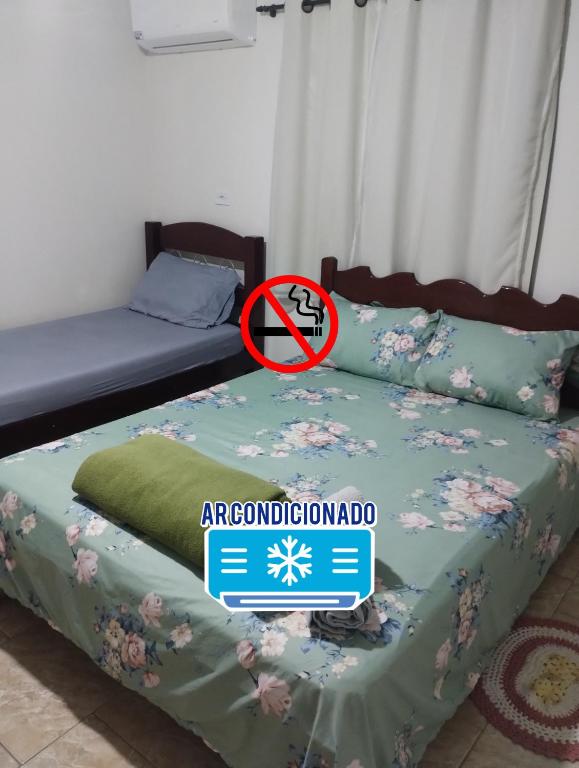 a bed in a room with a sign that says abnormalomed at Edícula 1 em São Pedro in São Pedro