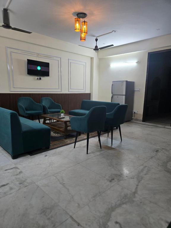 a waiting room with green chairs and a table at Gitanjali luxury in New Delhi