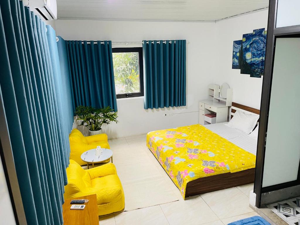 a bedroom with a bed and a yellow couch at Villa KimAnh in Sóc Sơn