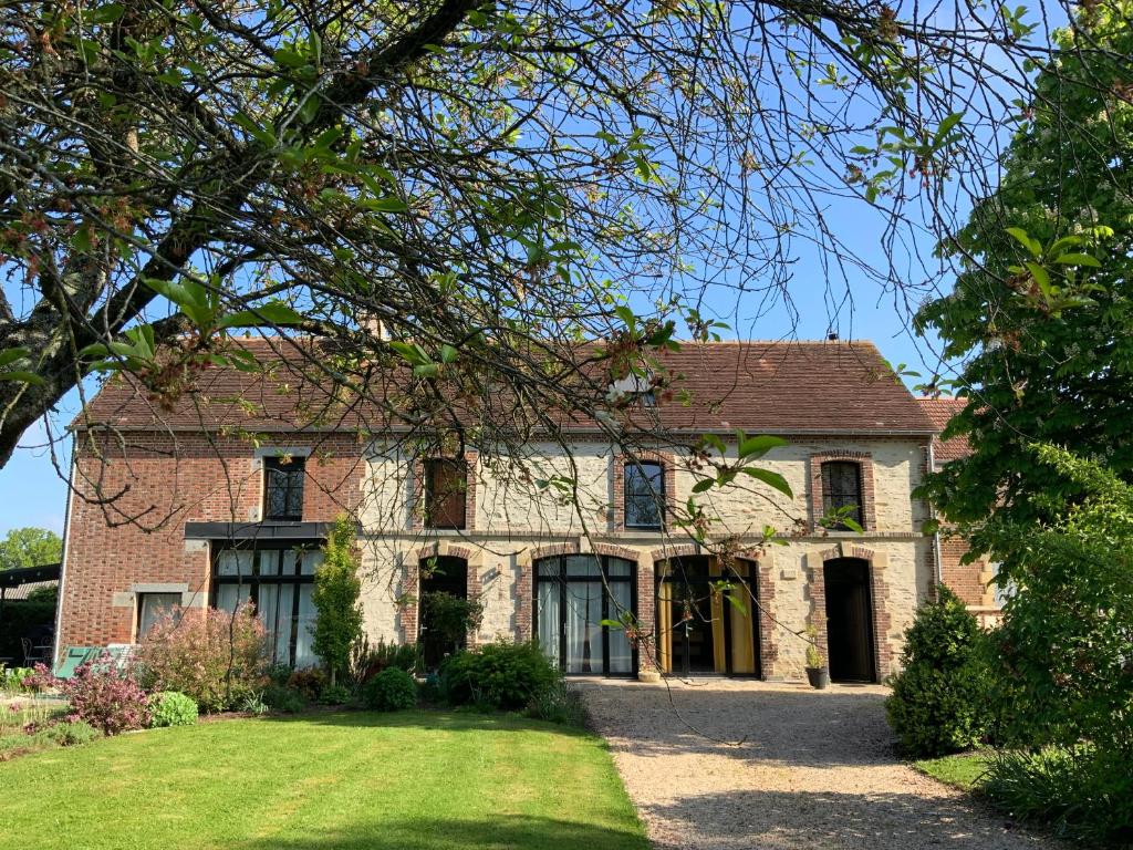 an old brick house with a tree at La Grange des Loges in Boucé