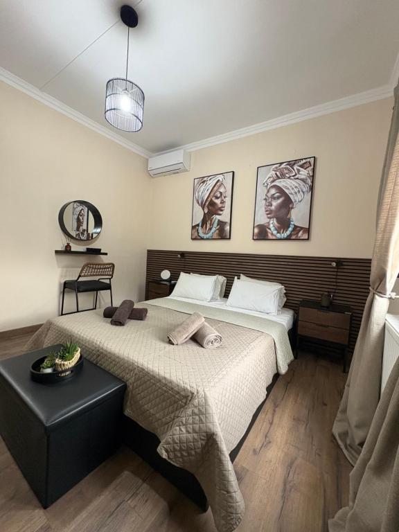 a bedroom with a bed and a table and pictures on the wall at MP House Kassandrino Halkidiki in Kassandrinón