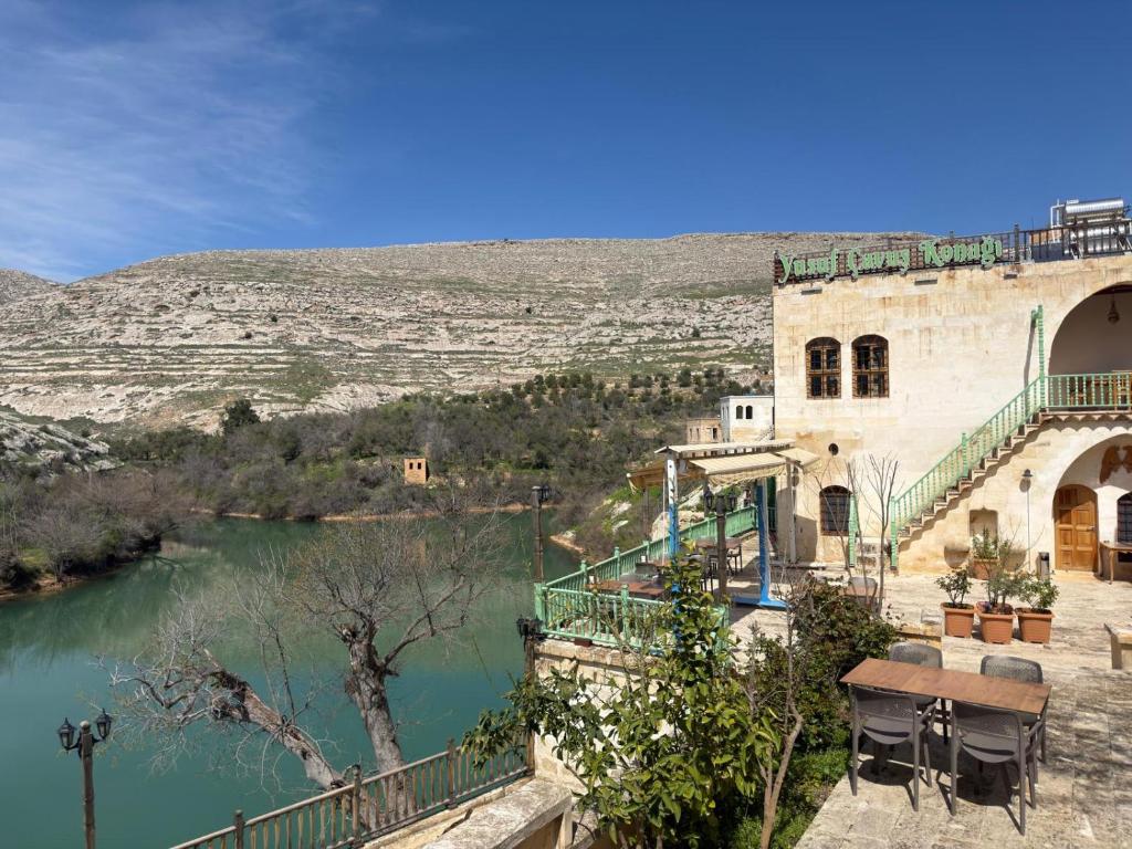 a building with a balcony next to a river at Yusuf Çavuş Konağı in Halfeti