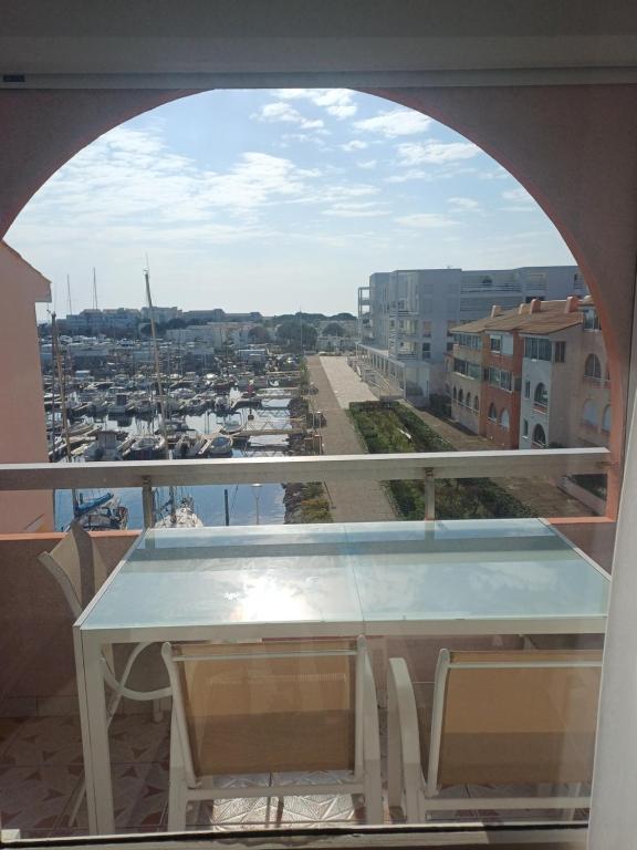 a table on a balcony with a view of a harbor at Le goéland in Port Leucate