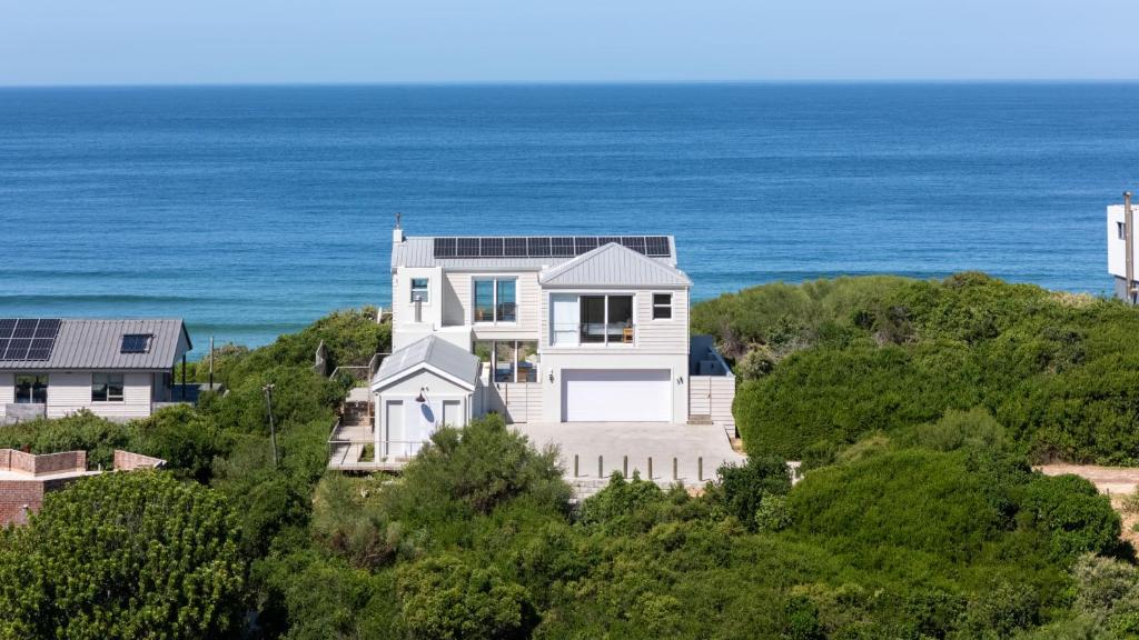 an aerial view of a house with the ocean in the background at Fijnduin Beach House in Keurboomstrand