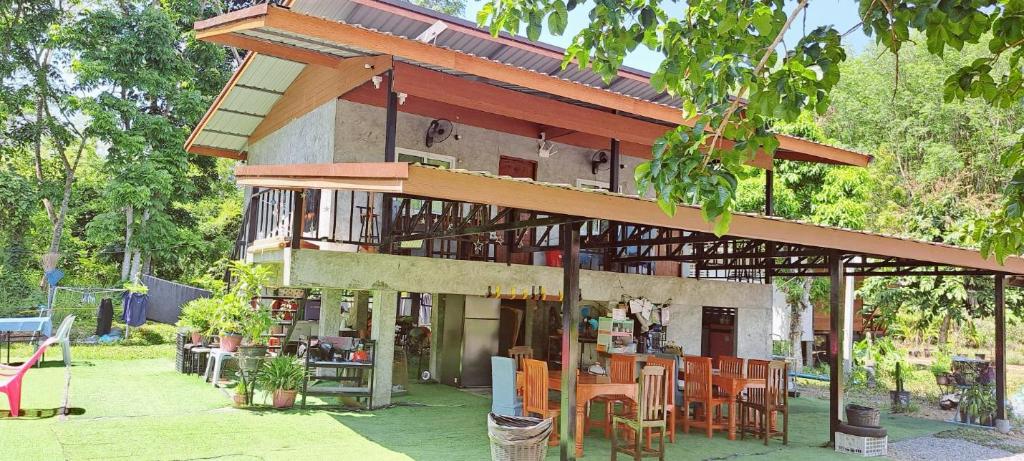 a building with a lot of tables and chairs at Yao Noi Hostel by KR in Ko Yao Noi