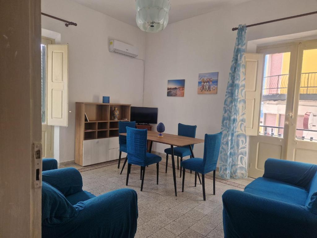 a dining room with blue chairs and a table at Brezza Marina in Bova Marina