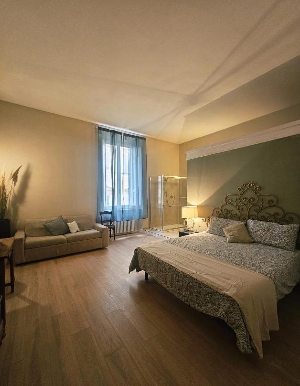 a bedroom with a large bed and a couch at Aria di Mare - Tra Centro e Porto in Livorno