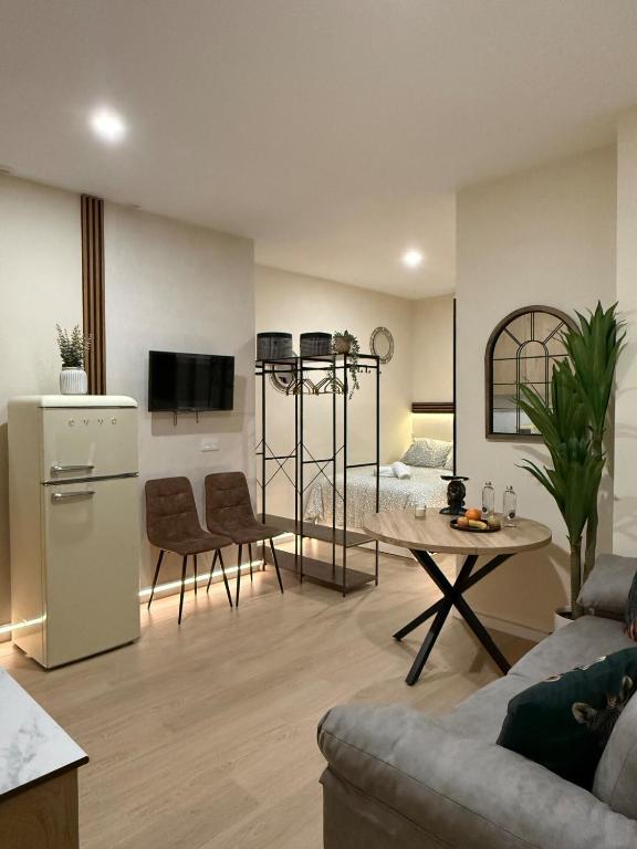a kitchen and living room with a couch and a table at Bianca Suites II in Bormujos
