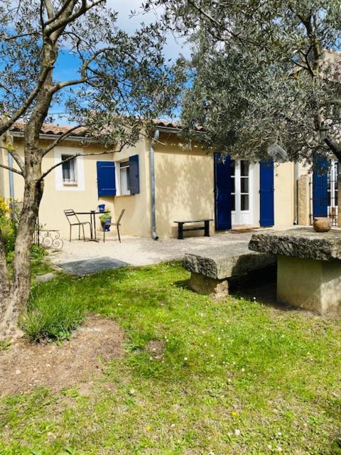 a house with blue doors and a bench in front of it at Studio Chez Joelle in Carpentras