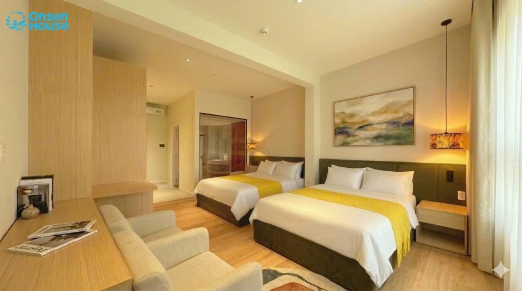 a hotel room with two beds and a desk at OnsenHouse Boutique Stay - Căn hộ gần biển Mỹ Khê in Danang