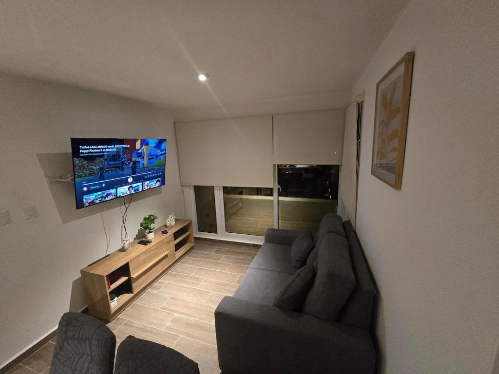a living room with a couch and a flat screen tv at Apartamento La Villa del Castillo in El Rodeo