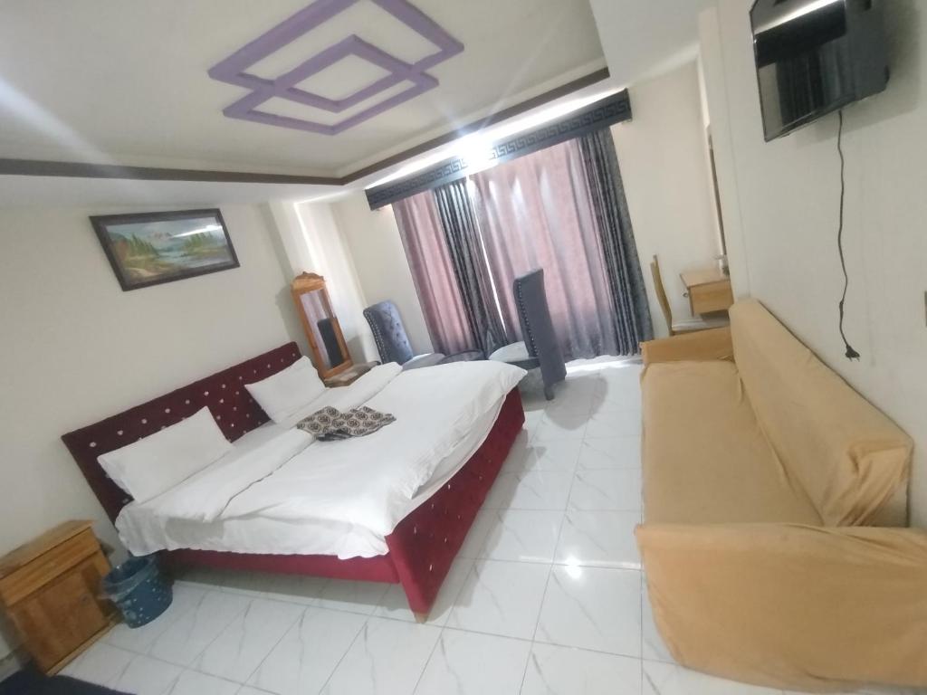 a hotel room with a bed and a couch at Hotel Crown Palace in Dunga Gali