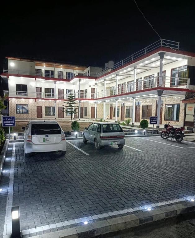 two cars parked in a parking lot in front of a building at Balakot View Hotel in Bauli