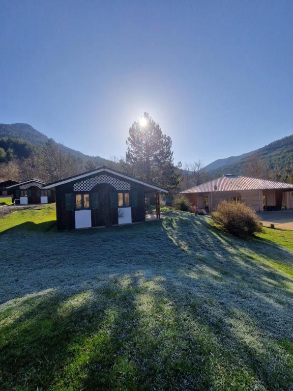 a house on a field with the sun shining on it at Chanteduc in Beaurières