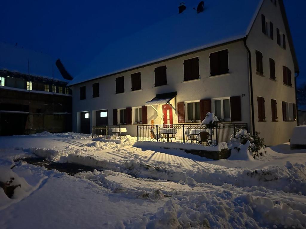 a building with a lot of snow in front of it at Gästehaus AlbTraum in Reutti
