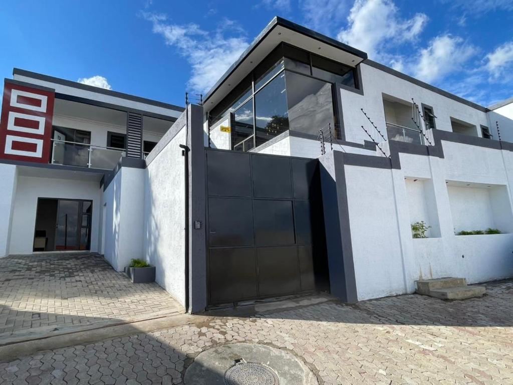 a white house with a large garage at Premium View Guesthouse in Windhoek