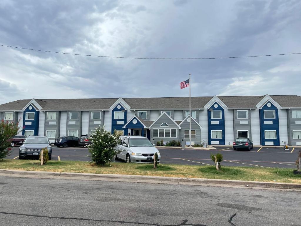 a large apartment building with cars parked in a parking lot at Microtel Inn & Suites by Wyndham Ardmore in Ardmore