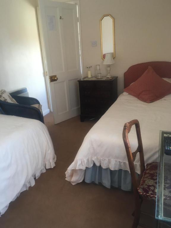 1 dormitorio con 2 camas, mesa y espejo en West Wold Farm House B&B, en Barton-upon-Humber