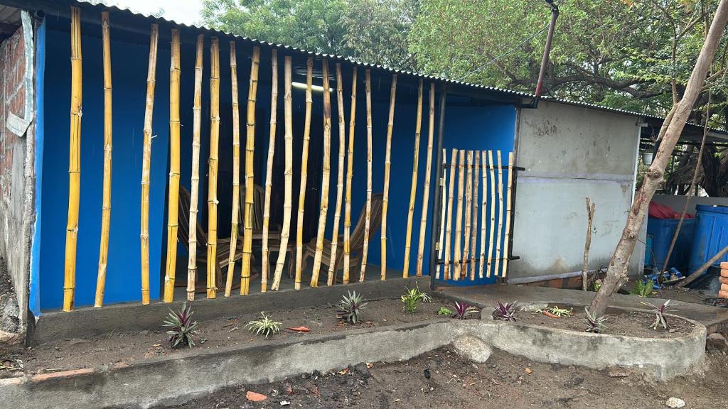 a blue building with a fence and some plants at Habitaciones Lala in Las Peñitas
