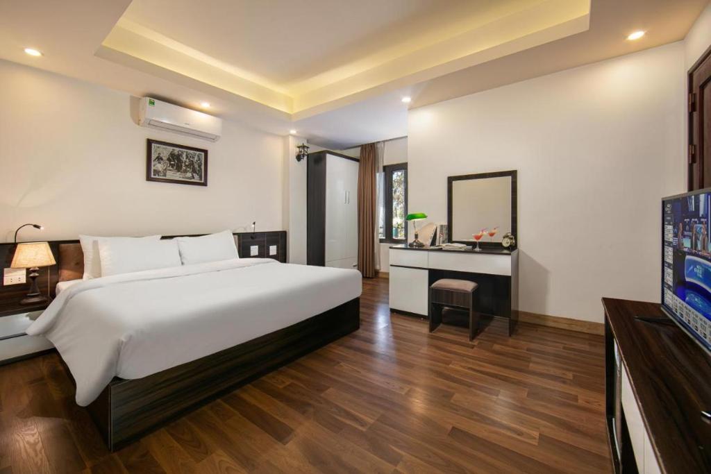 a bedroom with a bed and a desk and a television at Hotel Del Couple Sapa in Sapa