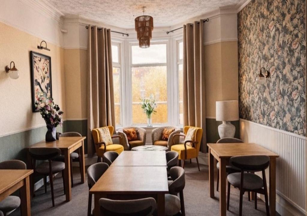 a waiting room with a couch and tables and chairs at The Franklyn Hotel B&B in Blackpool
