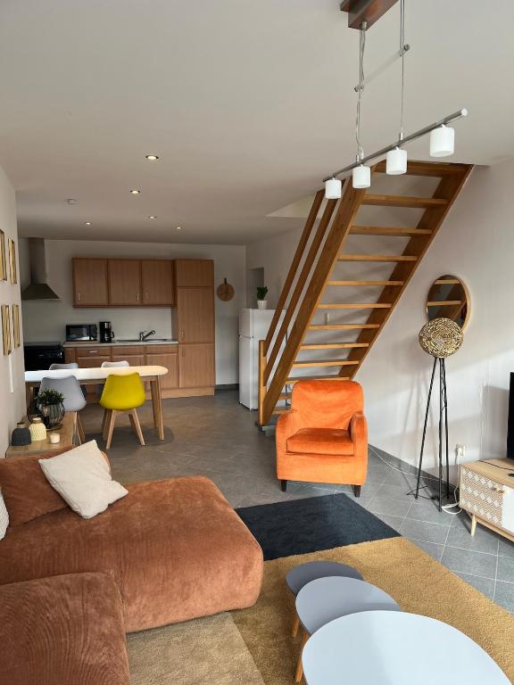 a living room with a couch and a staircase at The 8th in Léglise