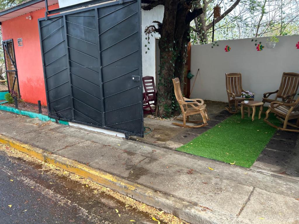 a black door in the side of a house with chairs at Casa Tamarindo in Las Peñitas