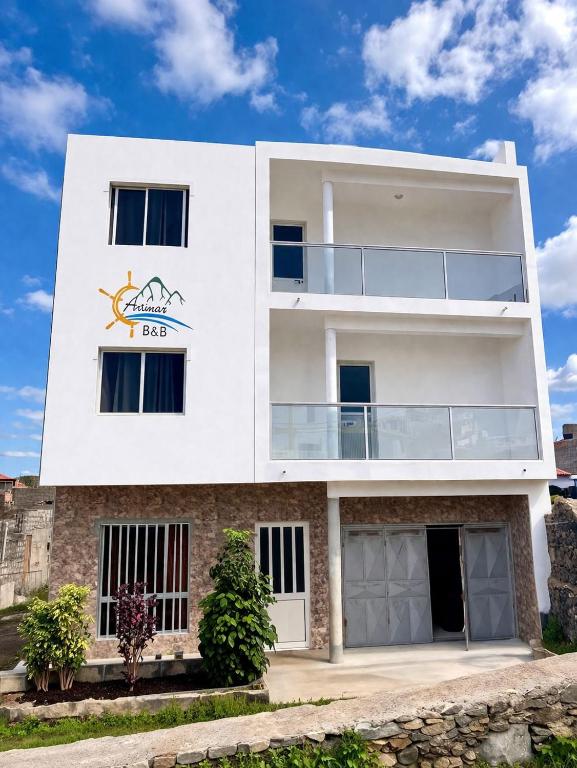 a white building with a sign on it at Artimar- B&Breakfast in Ponta do Sol