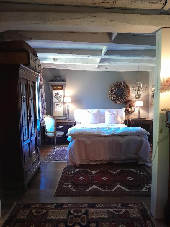 a bedroom with a bed and a desk and a chair at la maison de Royer in Meuzac
