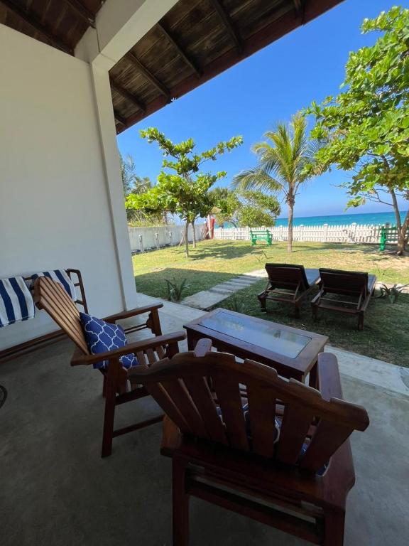 a patio with two chairs and a table at Pearl Oceanic Resort - Trincomalee in Trincomalee