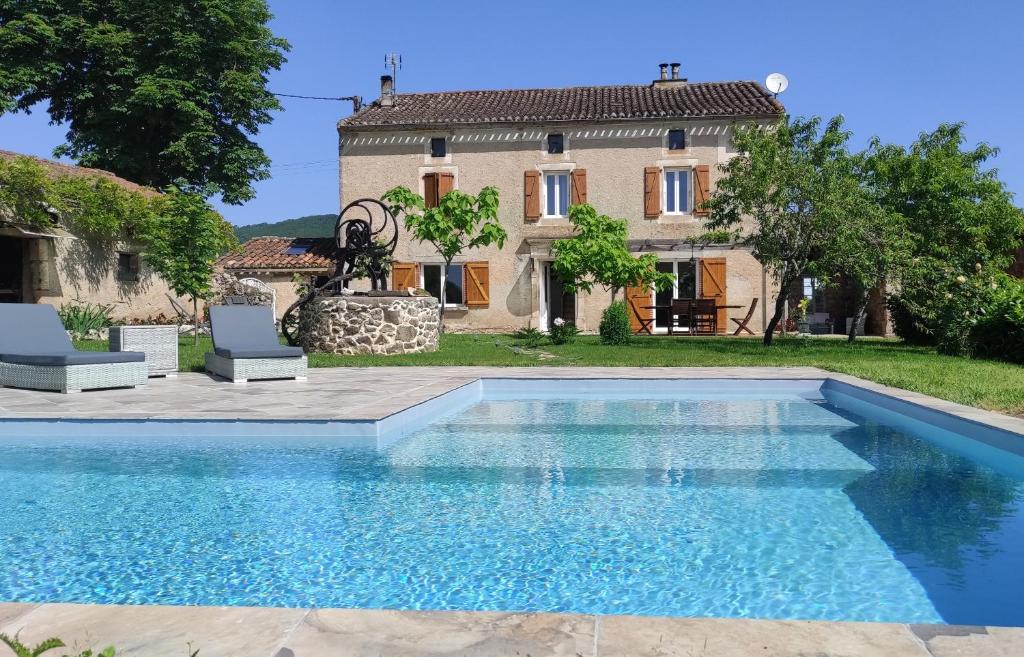 a villa with a swimming pool in front of a house at La Maison d'eglantine in Marnaves