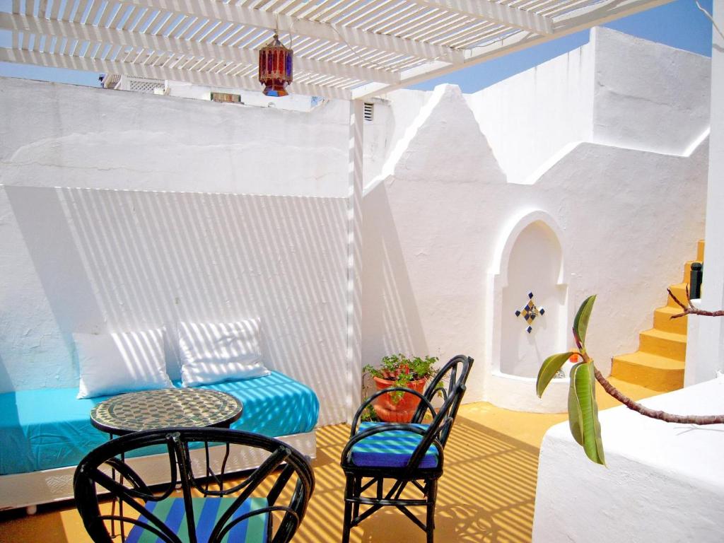 a room with two chairs and a table and a table and chairs at JIBARI, riad luminoso con patio en la medina de Asilah in Asilah