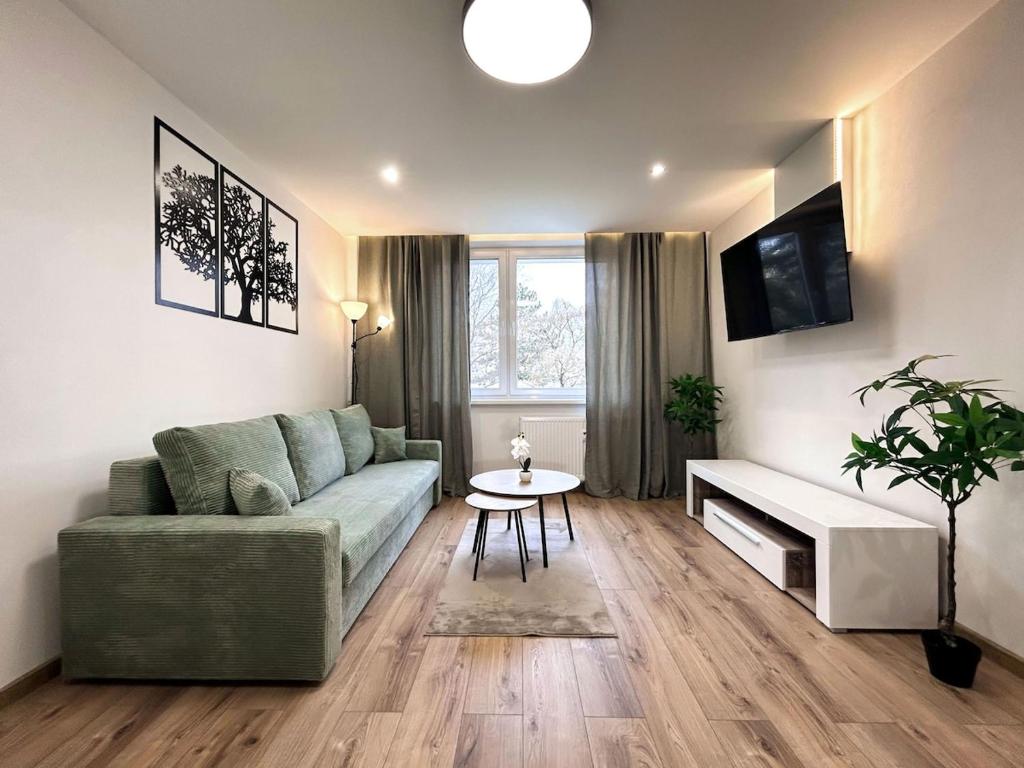 a living room with a couch and a table at Green Oasis Apartment in Myslava
