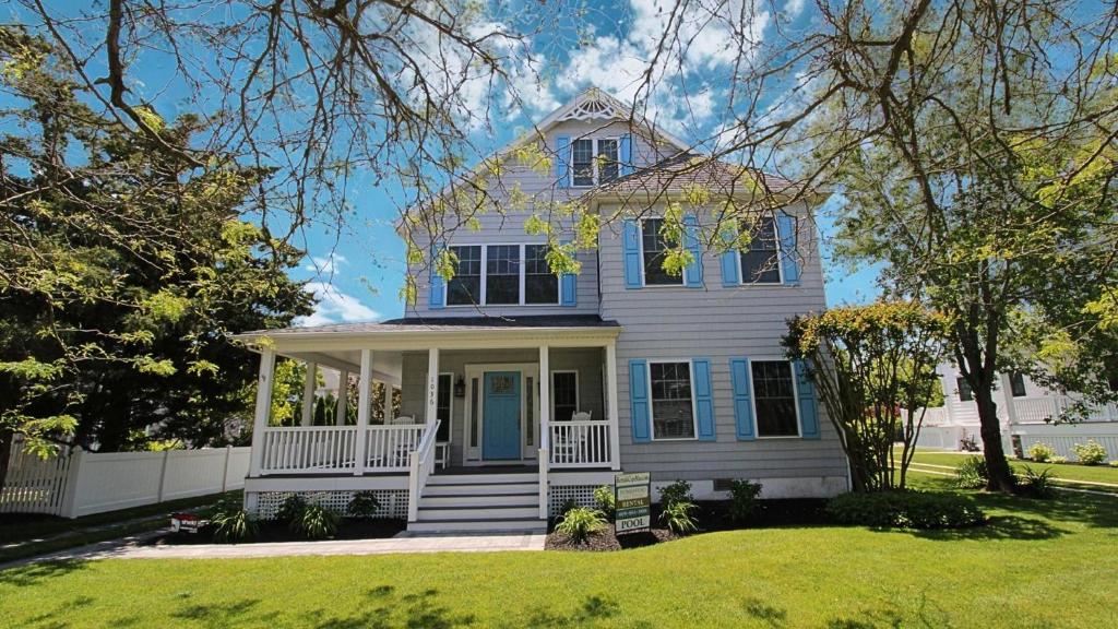 a white house with a blue door on a lawn at 1036 Maryland Ave in Cape May
