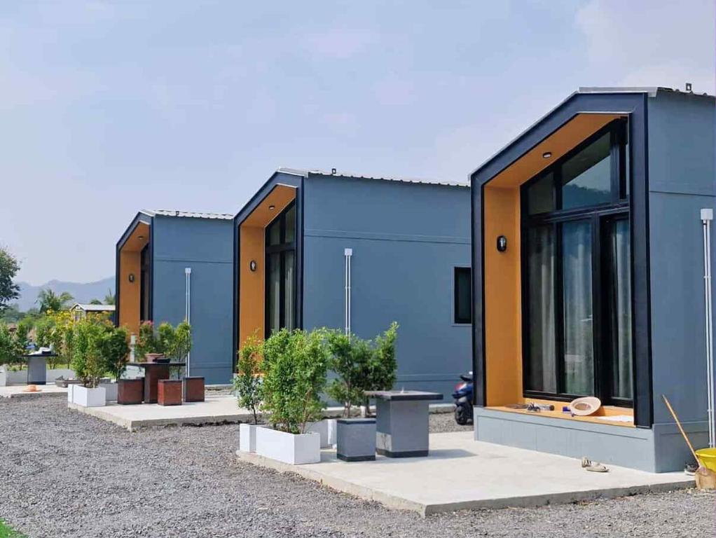 a blue building with potted plants in front of it at Baan Noah บ้านโนอาห์ in Lop Buri