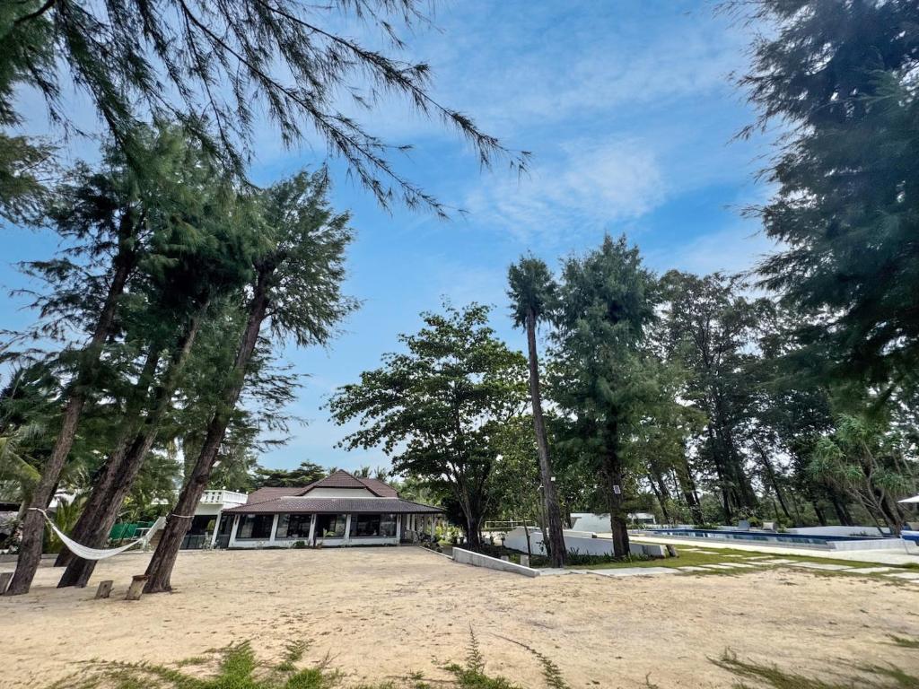 a house with a hammock in a park with trees at Sirinary Villa - Natai Phangnga in Ban Na Tai
