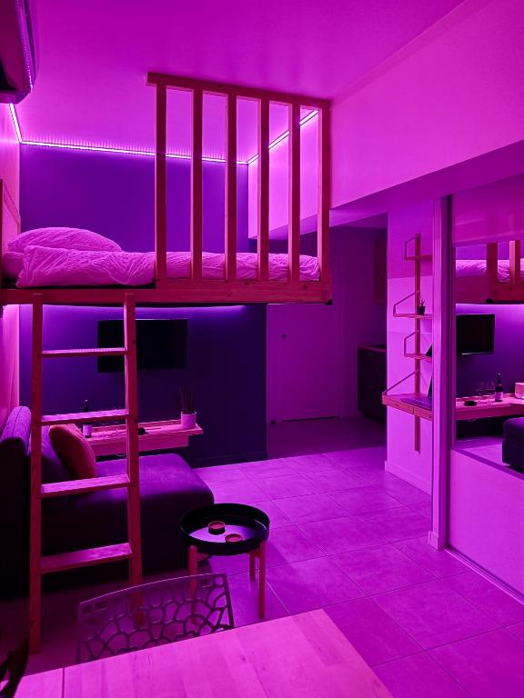 a room with two bunk beds with purple lighting at Studio du faubourg 1 à 3 Personnes in Valence