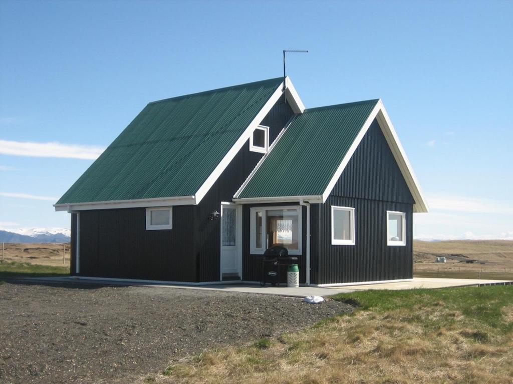 a black and white house with a green roof at Mid-Sel mountain view lodge in Hella